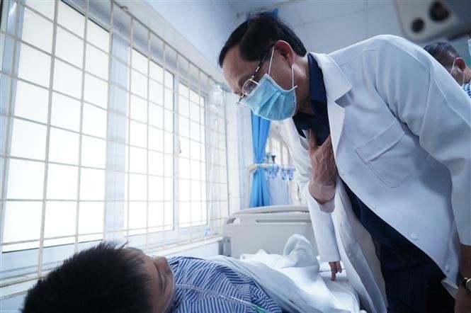 Vice Chairman of the National Assembly Tran Quang Phuong visits a fire victim at the Transport Hospital in Hanoi on May 24. (Photo: VNA)