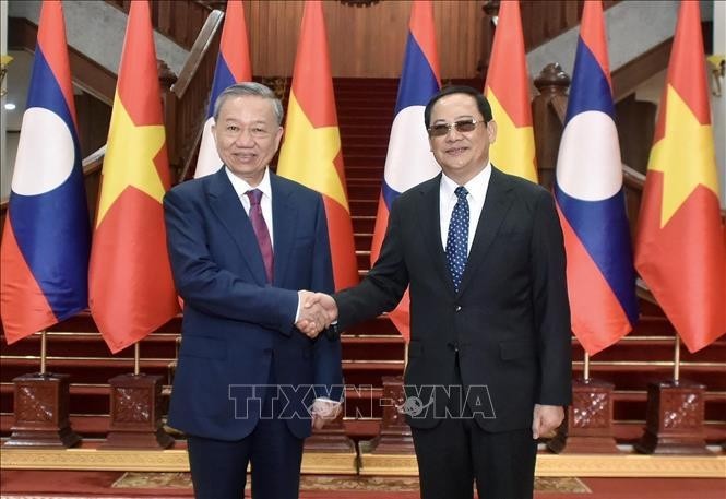 President To Lam (L) shakes hands with Lao Prime Minister Sonexay Siphandone (Photo: VNA)