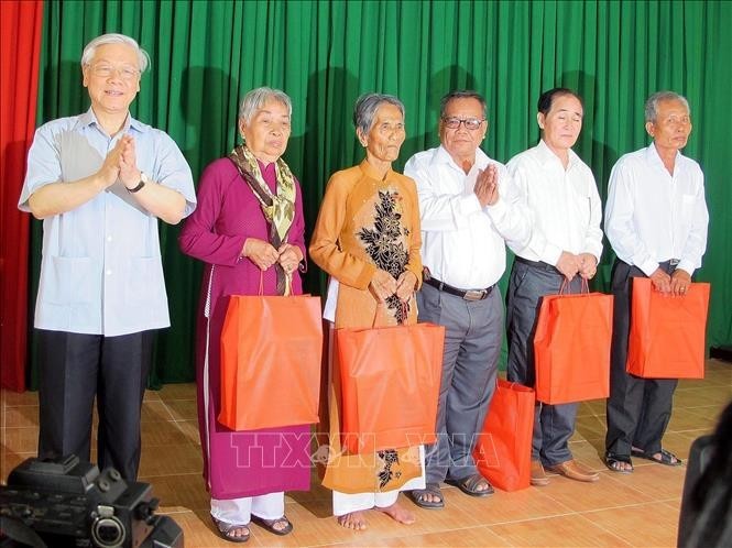 Party General Secretary Nguyen Phu Trong (first, left) gives presents to policy beneficiary families in the southern province of Soc Trang during his visit to My Xuyen district in 2015. (Photo: VNA)