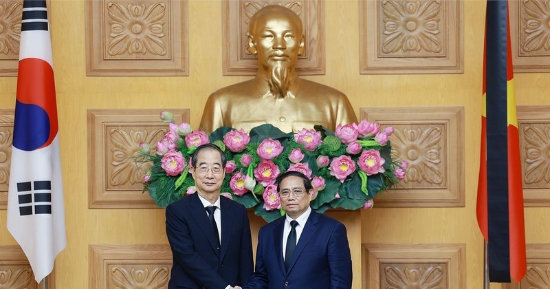 Prime Minister Pham Minh Chinh (R) hosts a reception for his Korean counterpart Han Duck Soo. (Photo: VNA)