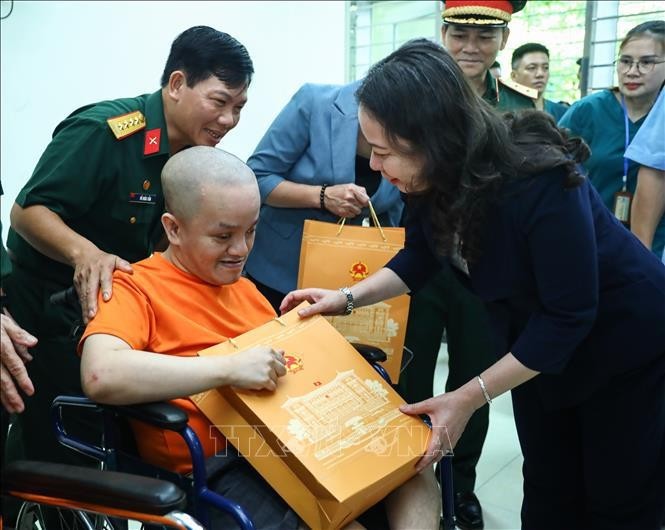 Vice President Vo Thi Anh Xuan gives a gift to an AO victims at the centre for caring, nurturing and treating victims of AO/dioxin in Ba Vi district, Hanoi. (Photo: VNA)