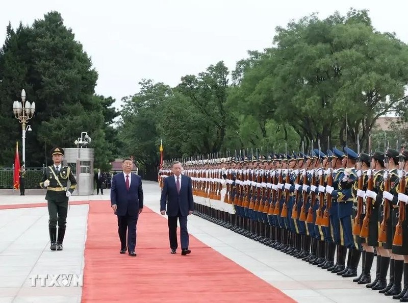 Lam and Xi pass an honour guard during a welcome ceremony for the former. (Photo: VNA)