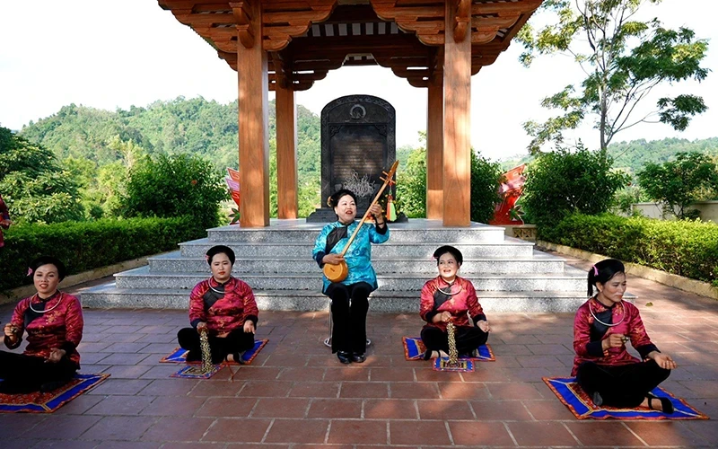 People's artisan Ha Mai Ven (middle) performs Then singing and Tinh lute at the festival of Thuy Hung Commune, Cao Loc District. (Photo: VI HUNG)