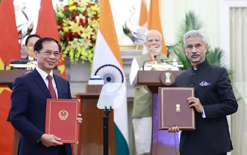 Leaders of the foreign ministries of Vietnam and India exchange an agreement between their governments allowing family members of diplomatic and consular staff to work for income. (Photo: VNA)