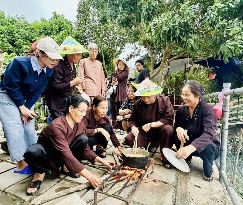 Tourists experience making 'banh duc' (steamed rice cake) when coming to the agricultural tourism model in Giang Bien (Long Bien district, Hanoi).