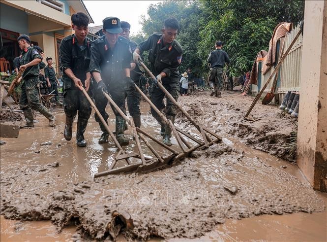 Mobile police clean up mud and houses for flood-hit people in Phuc Khanh commune, Bao Yen district, Lao Cai province. (Photo: VNA)