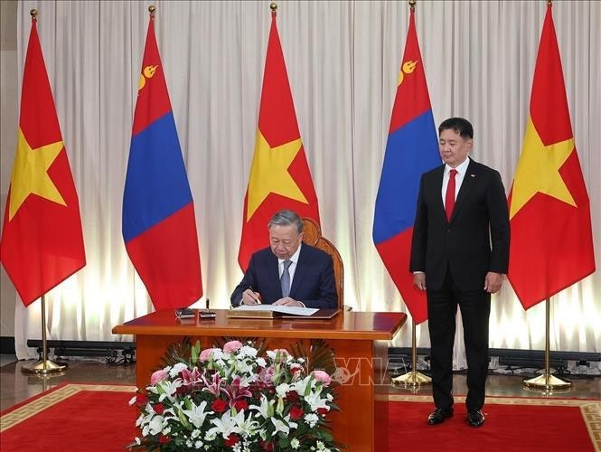 Party General Secretary and State President To Lam signs the honoured guest book in the presence of Mongolian President Ukhnaagiin Khurelsukh in Ulaanbaatar on September 30. (Photo: VNA)