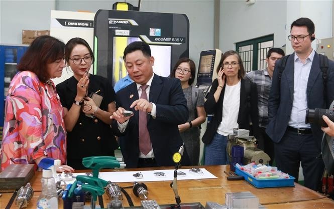 Parliamentary State Secretary to the Federal Ministry for Economic Cooperation and Development of Germany Bärbel Kofler ( first, left) is introduced to vocational training at LILAMA 2. (Photo: VNA)