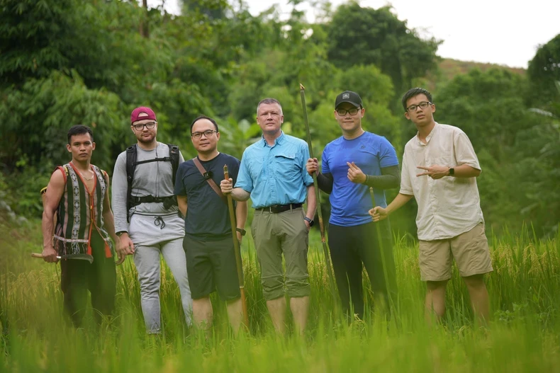 Professor K. David Harrison (in the middle of the blue shirt) brings students to live and work with the ethnic people to learn and research the culture and language of the Bahnar.