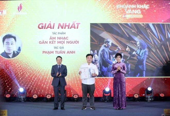 VNA General Director Vu Viet Trang (R) and Standing Vice Chairman of the Vietnam Journalists' Association Nguyen Duc Loi (L) present the first prize to Pham Tuan Anh at the event. (Photo: VNA)