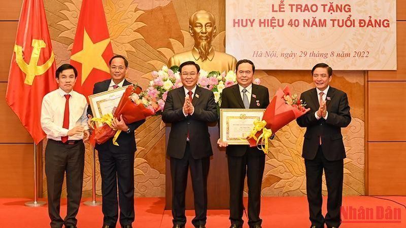 NA Chairman Vuong Dinh Hue presents 40-year Party membership badges to NA Vice Chairmen Tran Thanh Man and Tran Quang Phuong. (Photo: NDO/Duy Linh)