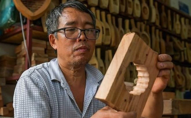 Tran Van Ban has nearly 40-year experience in making moon cake moulds (Photo: VNA)