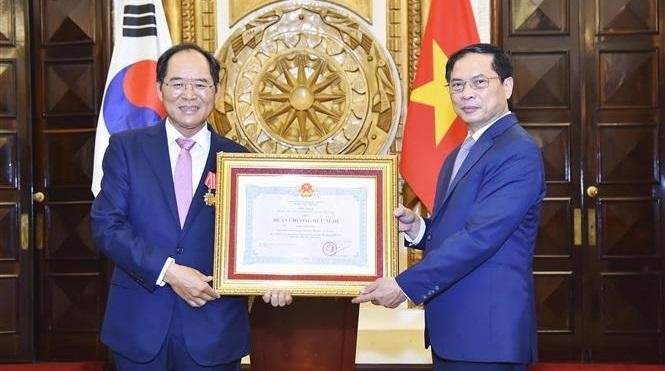 Minister of Foreign Affairs Bui Thanh Son (right) presents a Friendship Order to the outgoing Ambassador of the Republic of Korea (RoK), Park Noh-wan. (Photo: VNA)