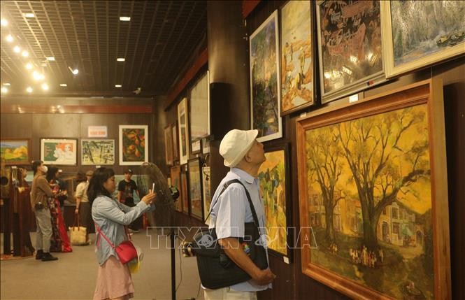 Visitors admiring artworks on display at the exhibition (Photo: VNA)