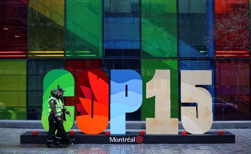 Police officers walk past a sign as they patrol outside the Palais de Congres, during the opening of COP15 in Montreal, Quebec, Canada. (Photo: REUTERS)