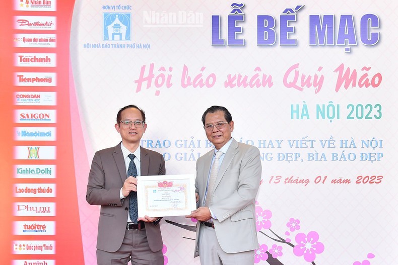 Chairman of the Hanoi Journalists’ Association To Quang Phan (R) presents the Best Cover prize to a representative from Nhan Dan Newspaper. 