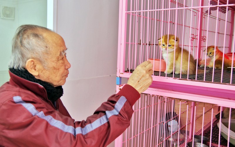 Poet Nguyen Bao Sinh, owner of the Bao Sinh Dog-Cat Resort, poses for a photo with a cat at his resort in Hanoi.