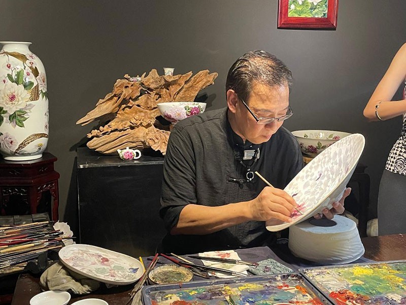 Painter Hong Duc Thanh demonstrates the art of painting on Bat Trang pottery products