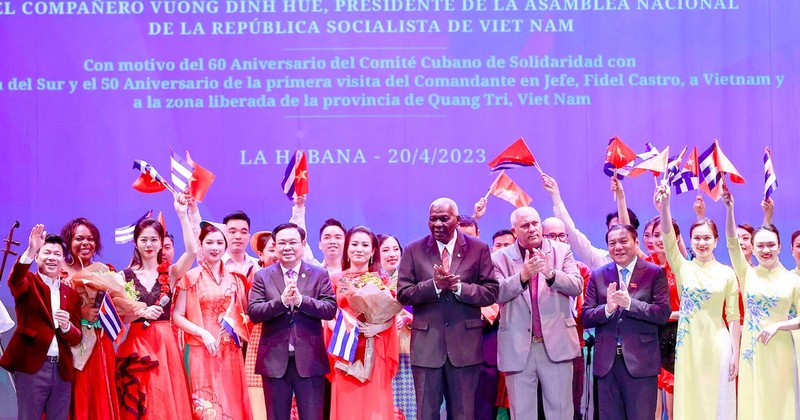 NA Chairman Vuong Dinh Hue and President of the NA of People's Power of Cuba Esteban Lazo Hernández present flowers to participating artists at the programme.