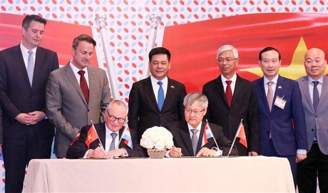 Luxembourg Prime Minister Xavier Bettel (standing, second from left) and delegates witness the signing of a memorandum of understanding between the VCCI and the Luxembourg Chamber of Commerce (Photo: VNA)