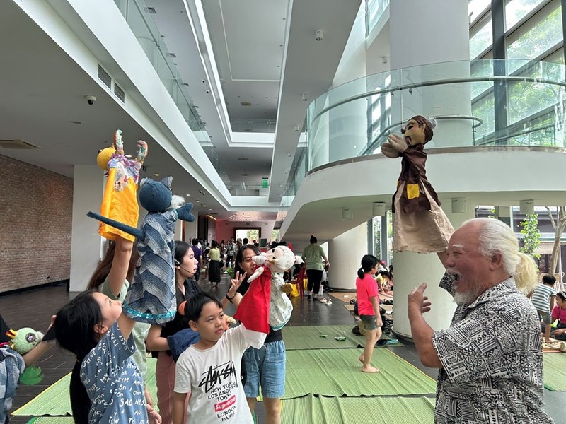 Children learn to control puppets under instruction of artist Duong Van Hoc. (Photo: daidoanket.vn)