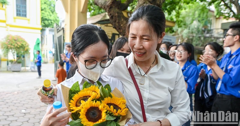 A candidate receives a bouquet of flowers from her relative after finishing the exam.