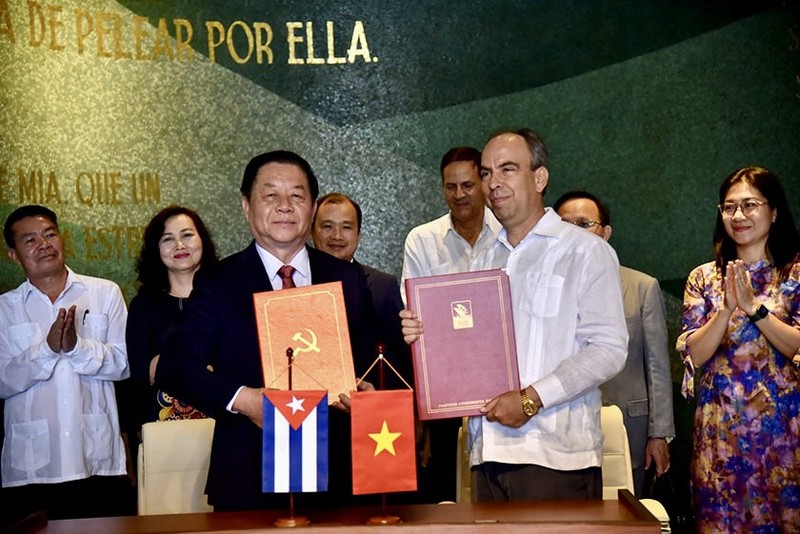 Secretary of the Party Central Committee and head of its Commission for Communication and Education Nguyen Trong Nghia (left, front) and Secretary of the Communist Party of Cuba Central Committee and head of its Ideological Department Rogelio Polanco Fuentes (right, front) sign a cooperation programme between the two sides (Photo: VNA)