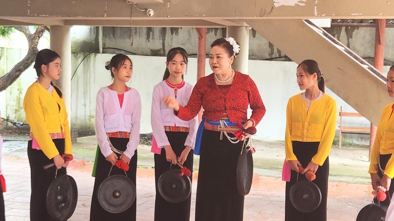 Dinh Thi Kieu Dung instructing local children on playing gongs