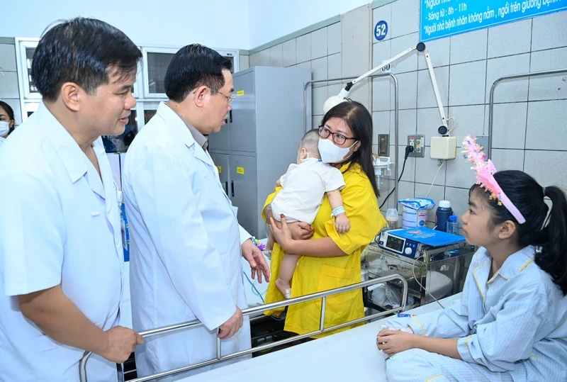 National Assembly Chairman Vuong Dinh Hue presents gifts to victims receiving treatment in Bach Mai hospital (Photo: NDO)