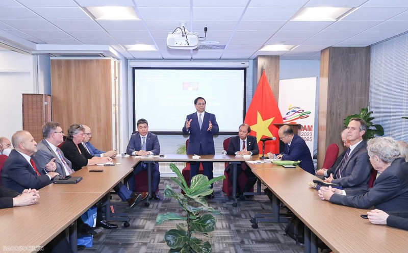 Prime Minister Pham Minh Chinh (centre) talks to the US friends. (Photo: baoquocte.vn)