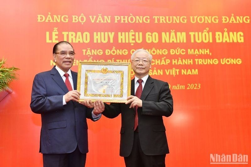 Party General Secretary Nguyen Phu Trong (R) presents the 60-year Party membership badge to his predecessor Nong Duc Manh on September 29. (Photo: NDO)