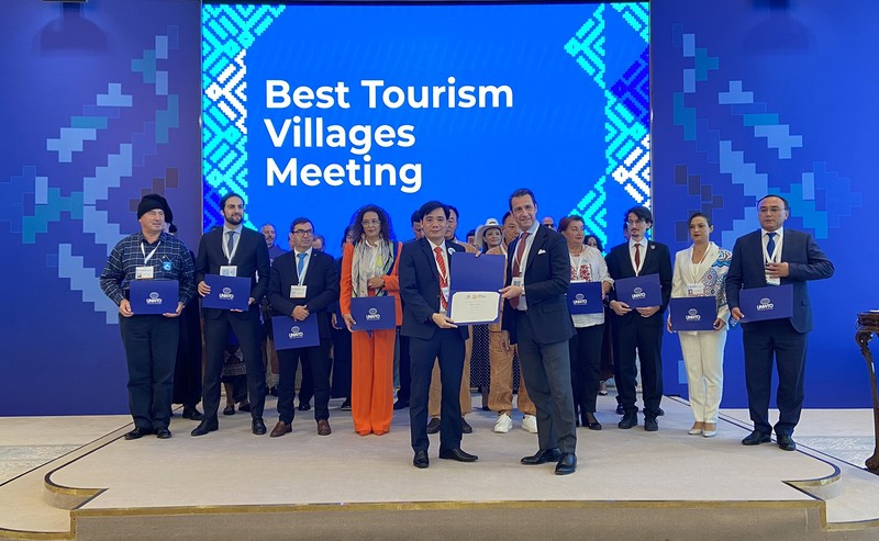 A leader of the Tan Hoa communal People's Committee receives the Best Tourism Village 2023 title from the World Tourism Organisation. (Photo: baoquangbinh.vn)