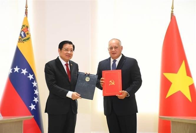 Politburo member, Secretary of the CPV Central Committee, Chairman of its Commission for Internal Affairs Phan Dinh Trac (L) and PSUV First Vice President Diosdado Cabello sign an agreement on cooperation between the CPV and PSUV (Photo: VNA)