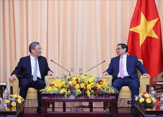 Prime Minister Pham Minh Chinh (R) receives Chinese Minister of Commerce Wang Wentao. (Photo: VNA) 