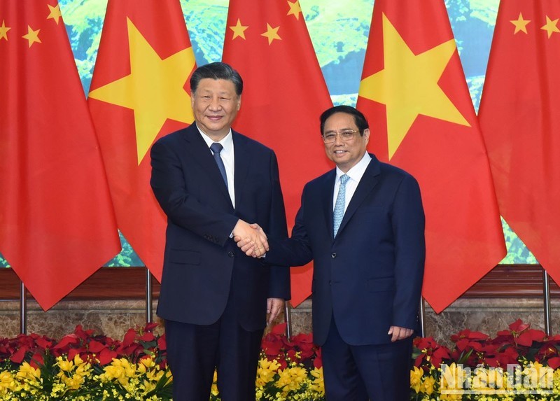 Prime Minister Pham Minh Chinh (R) warmly welcomes Chinese Party General Secretary and President Xi Jinping.
