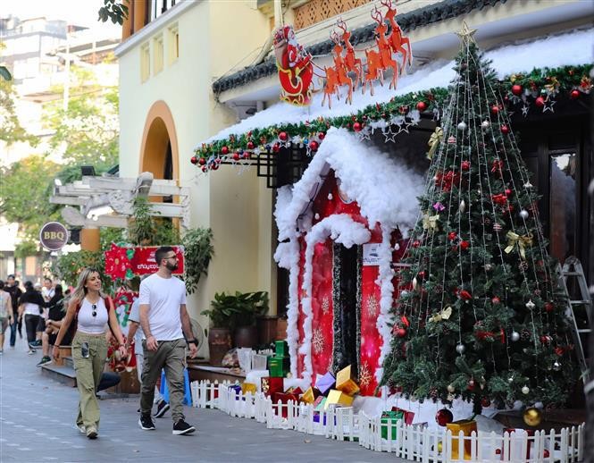 Foreign visitors walk on a street in Hanoi ahead of Christmas. (Photo: VNA)