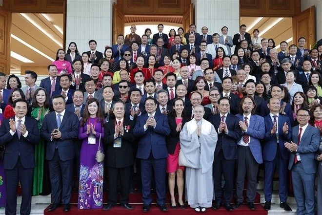 Prime Minister Pham Minh Chinh pose for a photo with OVs joining the Homeland Spiring programme in 2023 (Photo: VNA)
