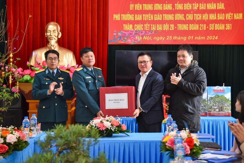 Nhan Dan Newspaper Editor-in-Chief Le Quoc Minh (third from left) presents gifts to air defence officers and soldiers ahead of Tet 