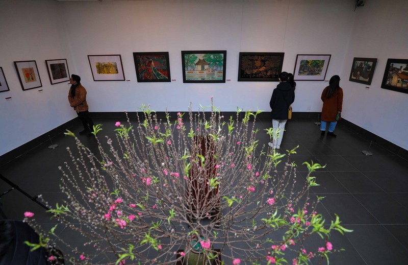 Visitors admiring paintings on display at the exhibition (Photo: VNA)