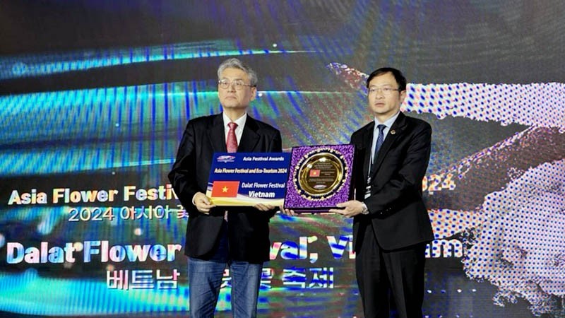 Chairman of Da Lat City People's Committee Dang Quang Tu (R) receives a certificate honouring Da Lat as Festival City of Asia 