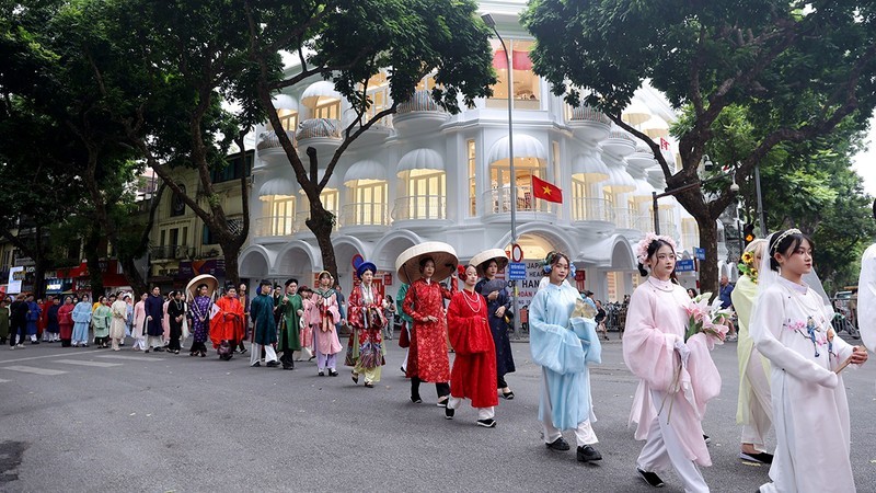 Young people dressed in ancient Vietnamese costumes join a parade at the 2023 Hanoi Ao Dai Festival.