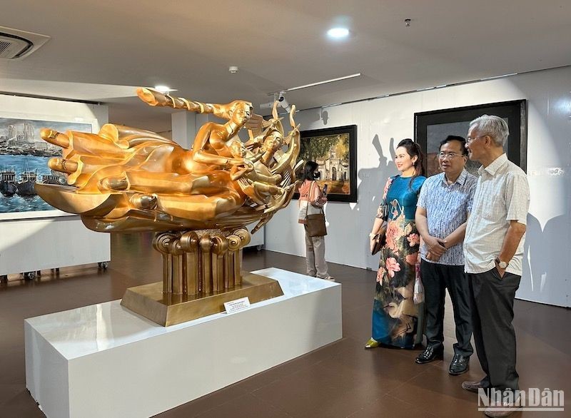 Visitors admire a sculpture on display at the exhibition 