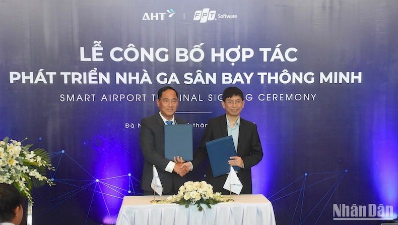 Deputy General Director the Da Nang International Terminal Investment and Operation JSC (AHT) Do Trong Hau (left) and a representative of FPT Software sign a cooperation document on April 22. (Photo: NDO)