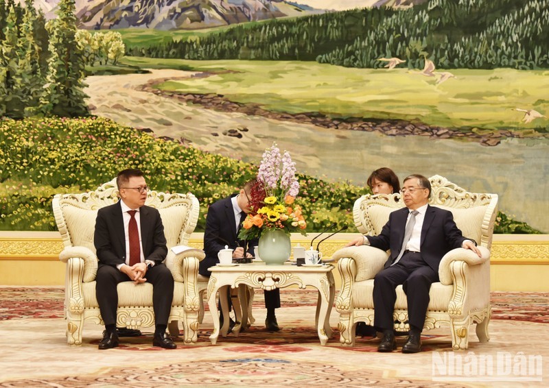 Head of the CPC Central Committee's Publicity Department Li Shulei (R) receives Nhan Dan Newspaper Editor-in-chief Le Quoc Minh 