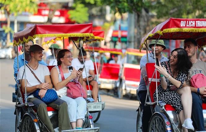 Foreign visitors touring the Hanoi Old Quarter on cyclos (Photo: VNA)