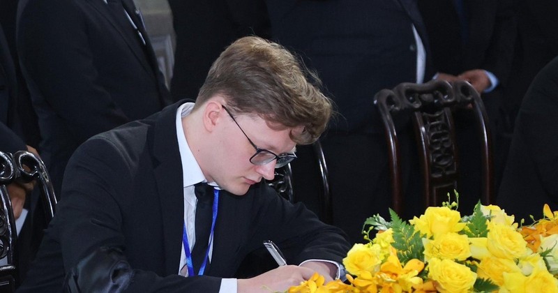 Kyril Whittaker, representative of the Communist Party of Britain (CPB), writes in the condolence book at the respect-paying service held for Party General Secretary Nguyen Phu Trong in Hanoi. (Photo: VNA)