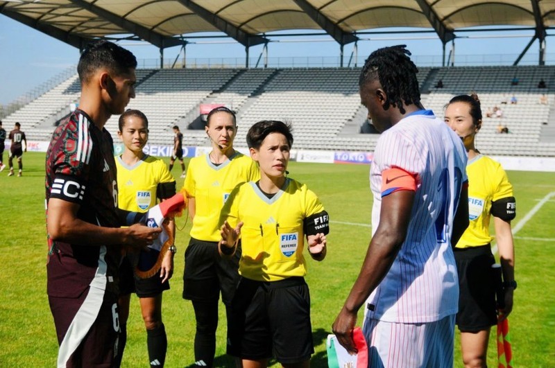 Female referee Le Thi Ly (middle) officiates an international match in France. (Photo: VFF)