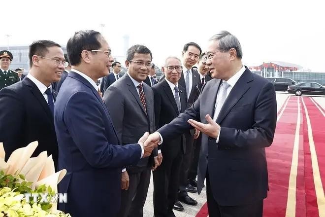 Deputy Prime Minister and Minister of Foreign Affairs Bui Thanh Son (first, left), Deputy Minister of Foreign Affairs Nguyen Minh Vu (second, left), and other officials bid farewell to Premier Li Qiang (R) at Noi Bai International Airport. (Photo: VNA)