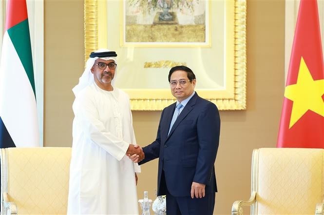 Prime Minister Pham Minh Chinh (R) shakes hands with Sheikh Hamad Bin Zayed Al Nahyan, Director of the Abu Dhabi Investment Authority (ADIA) of the UAE. (Photo: VNA)