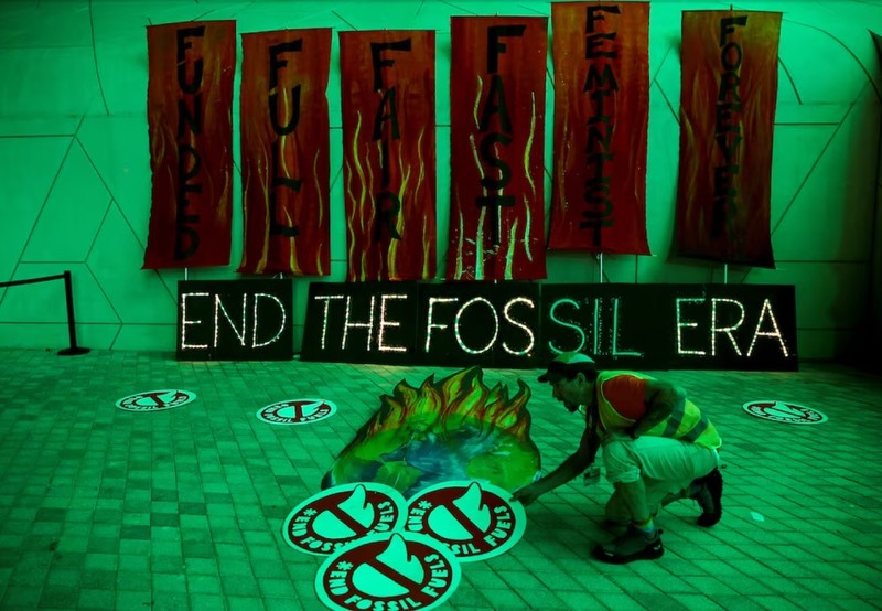 A climate activist arranges artwork against fossil fuels at Dubai's Expo City during the United Nations Climate Change Conference COP28 in Dubai, United Arab Emirates, December 12, 2023. (Photo: REUTERS)